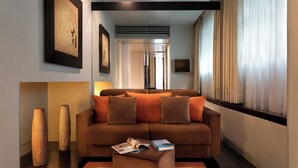 A modern living room with a sofa, a coffee table, and two vases. - Sina The Gray (Milan)