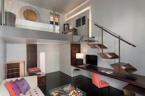 A modern interior with a staircase, a sofa, a coffee table, and a TV. - Sina The Gray (Milan)