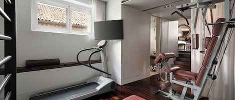 Una palestra moderna con tapis roulant, panche per pesi e attrezzature da allenamento.