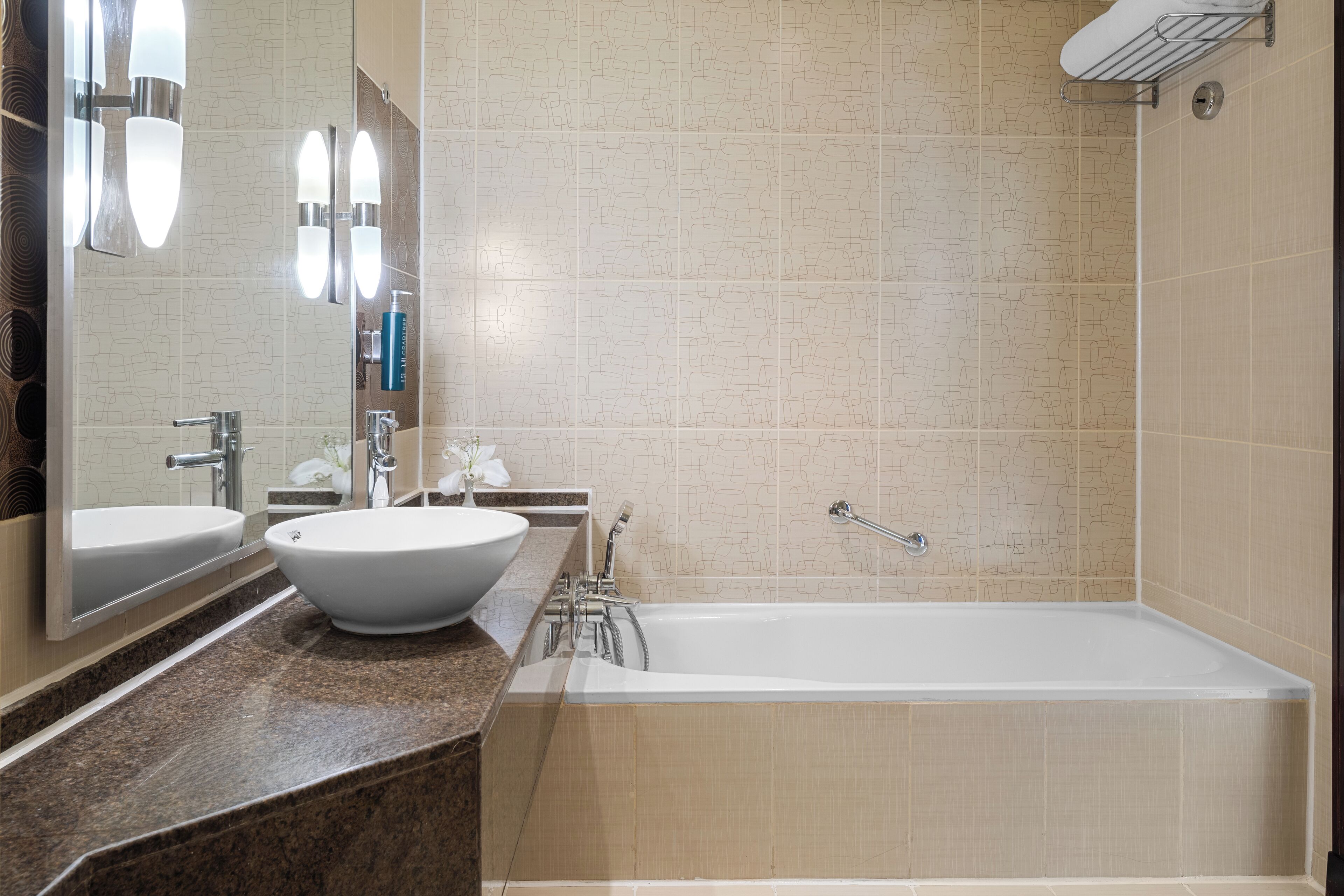 A modern bathroom with a large bathtub, two sinks, and a mirror.