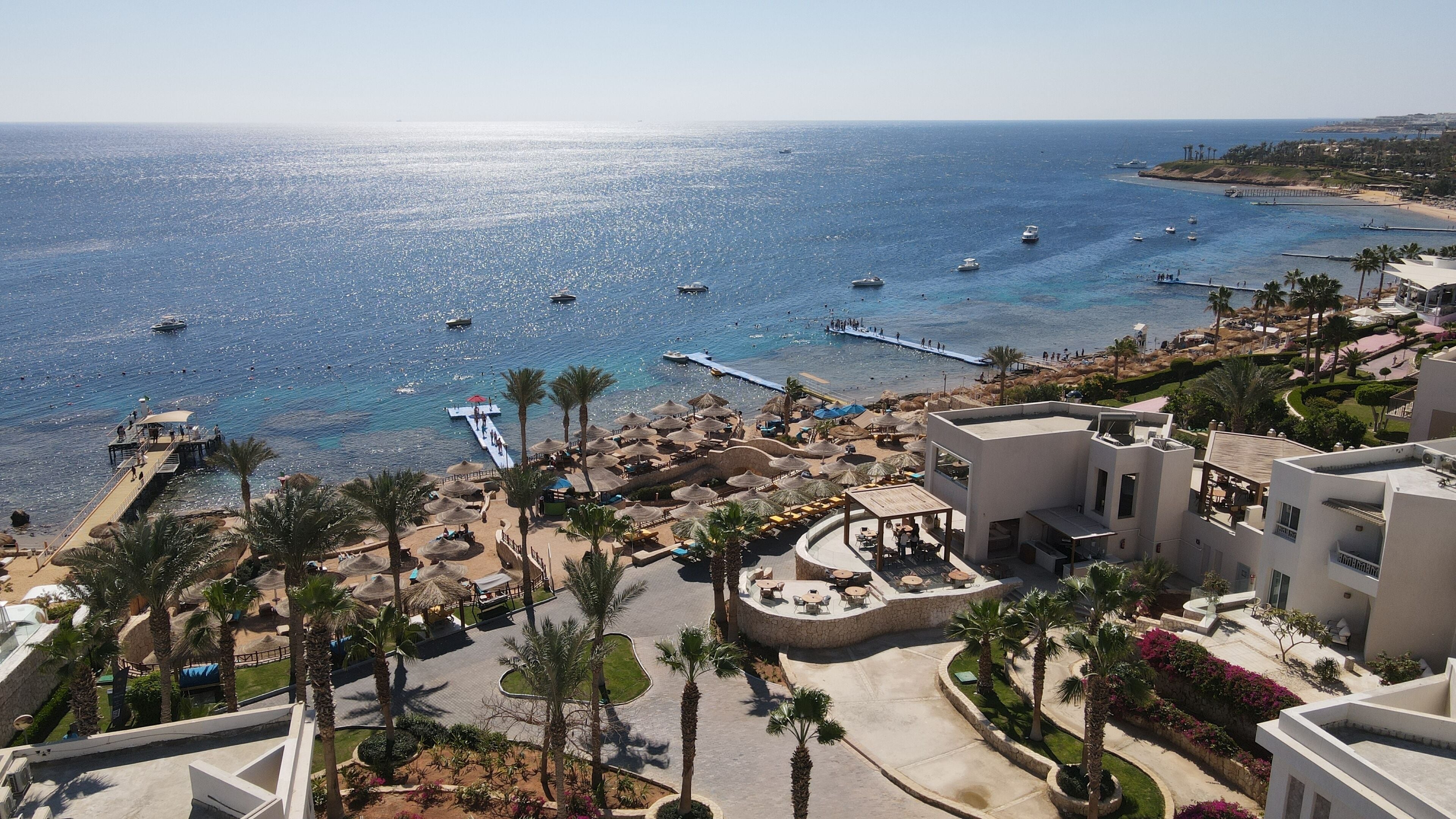 A coastal resort with a marina, palm trees, and a beach area.