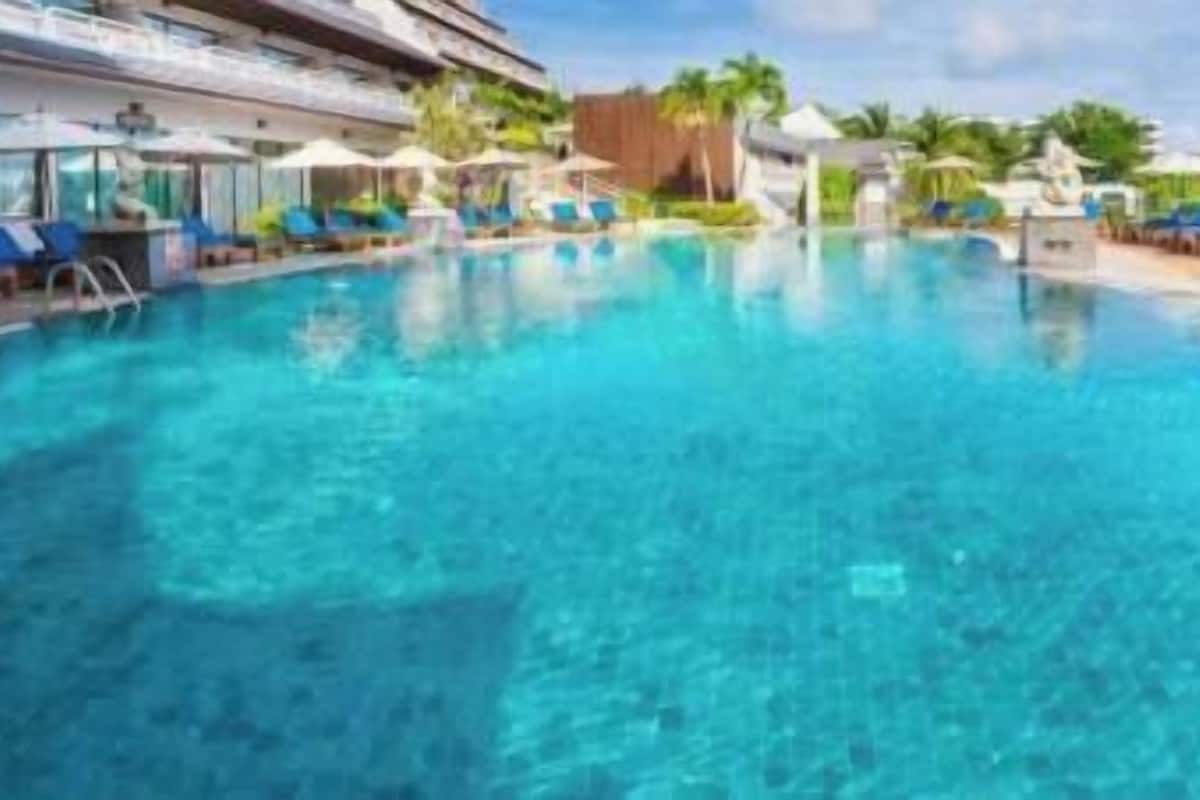 A clear swimming pool with lounge chairs and umbrellas.