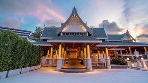 A traditional Thai building with a central entrance, columns, and a tiled roof.