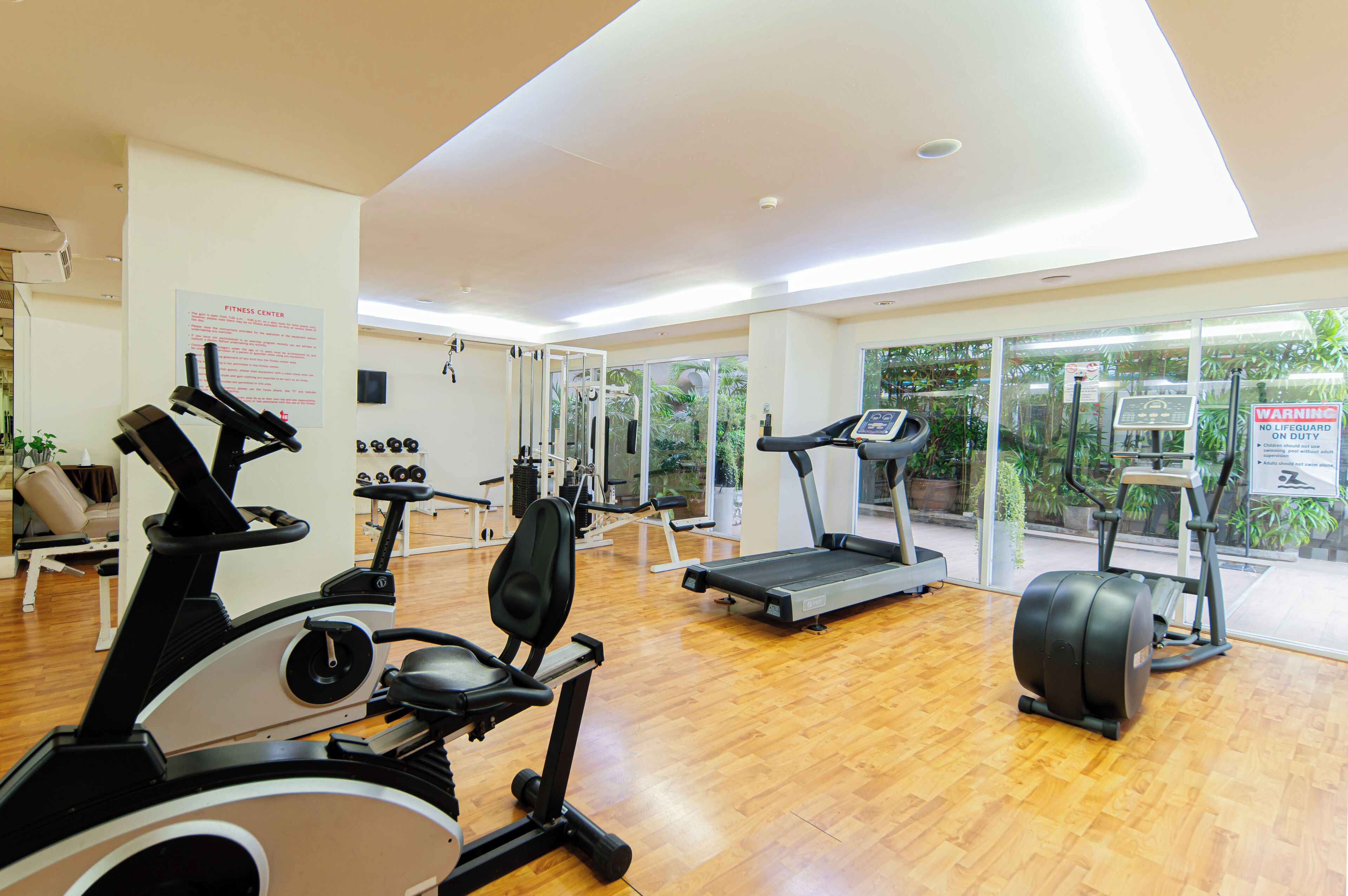 A fitness center with cardio machines, a treadmill, and weight equipment.