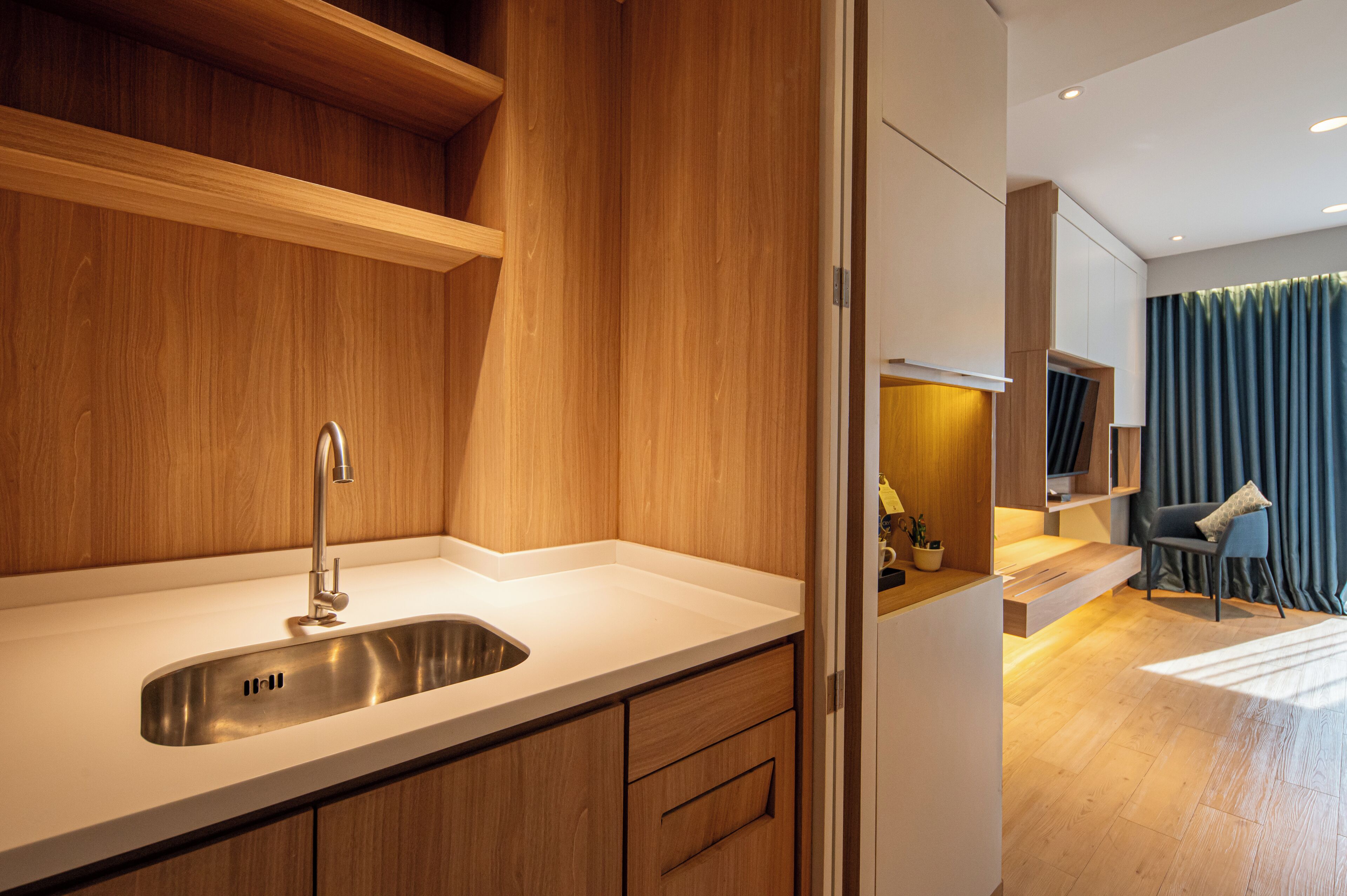 A modern kitchen with a stainless steel sink, wooden cabinetry, and a built-in oven.