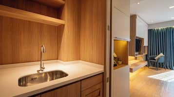 A modern kitchen with a stainless steel sink, wooden cabinetry, and a built-in oven.
