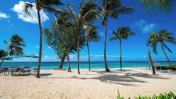 On the beach, white sand, sun loungers, beach umbrellas