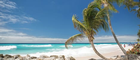 På stranden, hvit sand, solsenger og parasoller