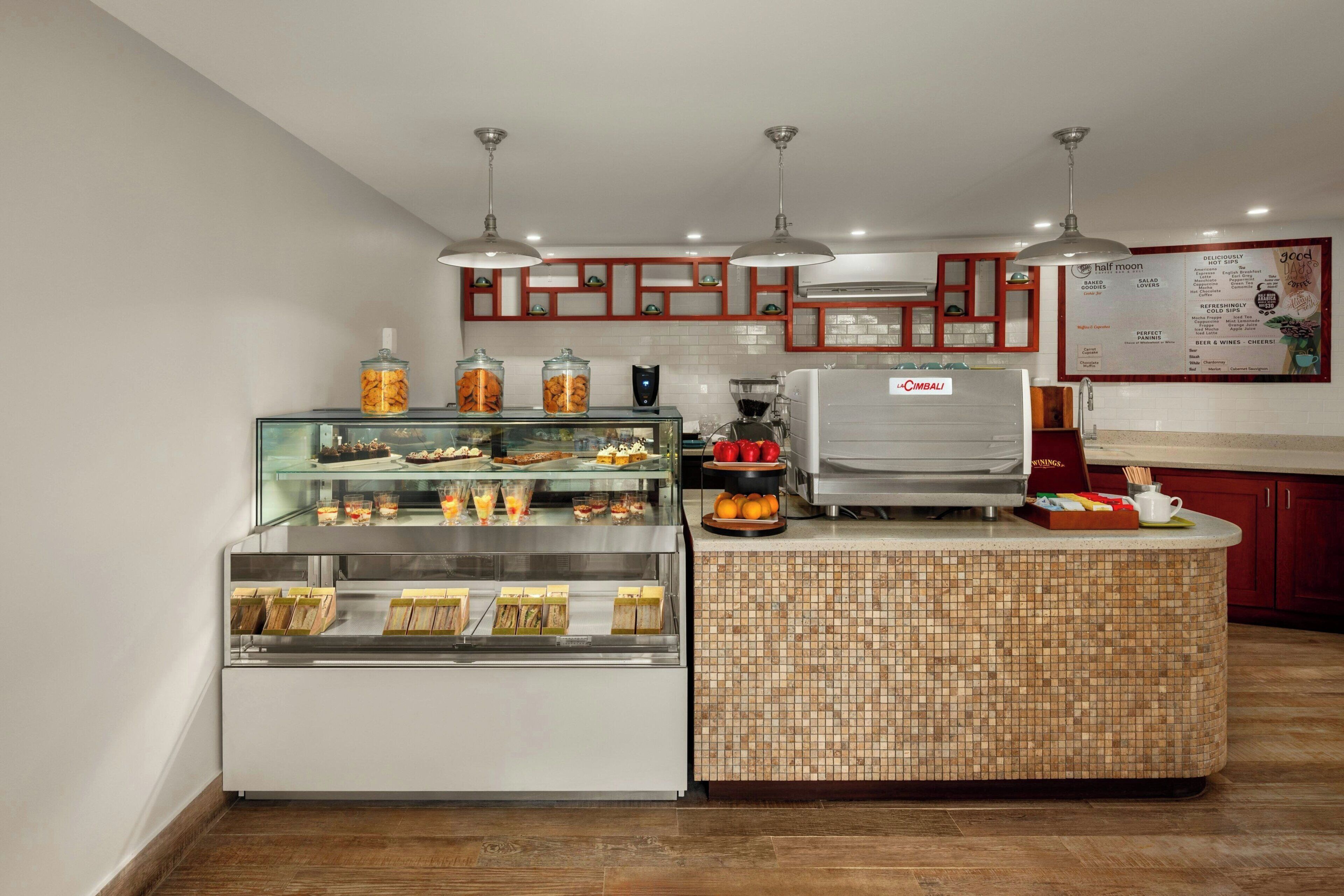 Un comptoir de boulangerie où sont exposés divers produits de boulangerie, ainsi qu’une machine à café.