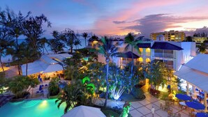 Un resort con piscina, palmeras y un edificio de varios pisos.