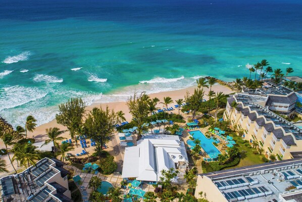 Un complexe hôtelier doté d’une piscine, d’une plage et offrant une vue sur l’océan.