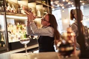 A bar setting with a bartender pouring a drink. - Novotel London Bridge (London)