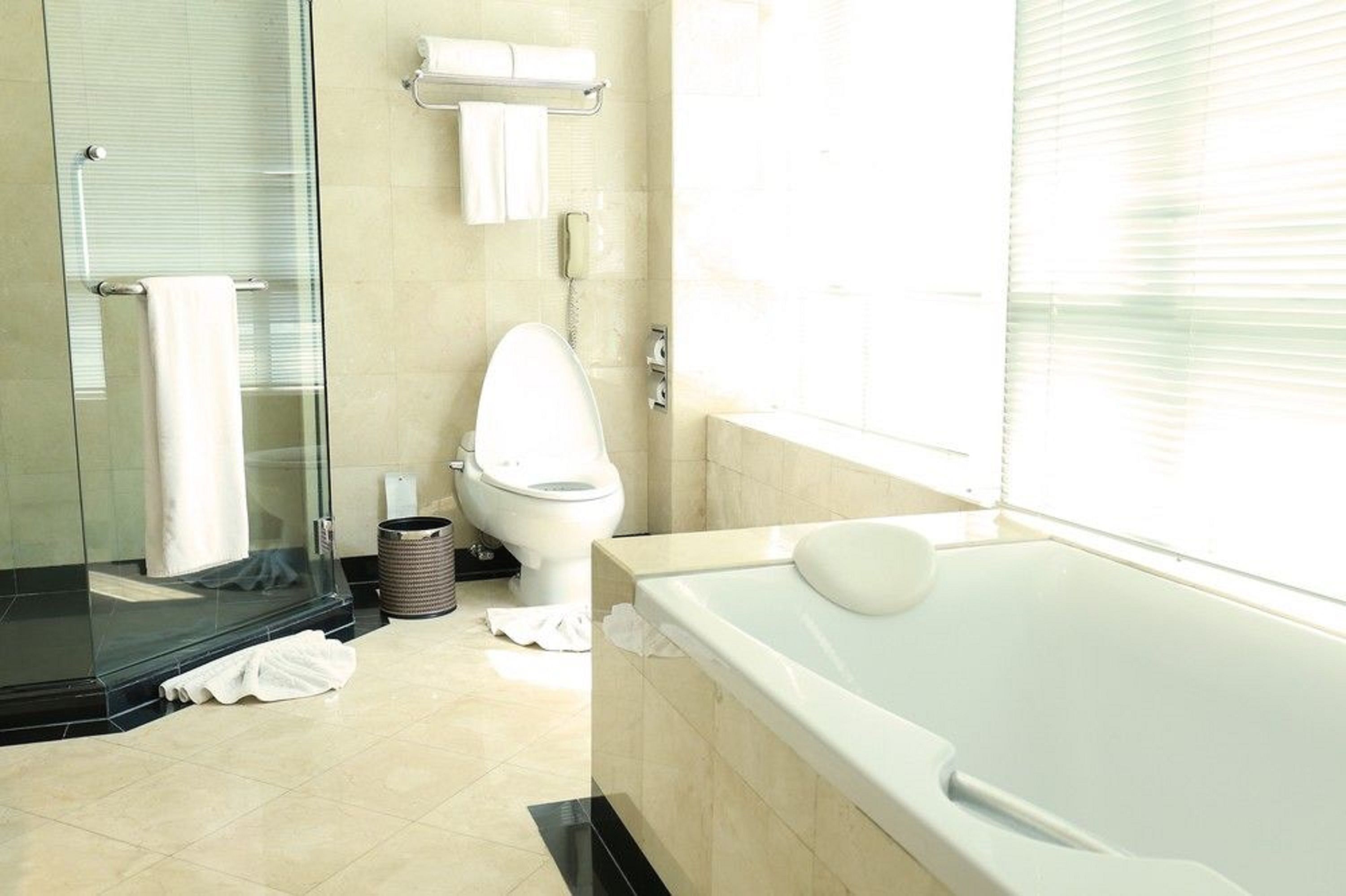 Un baño moderno con cabina de ducha de vidrio, inodoro y bañera.