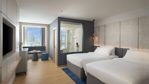 A modern hotel room with two beds, a TV, a seating area, and a large window offering a city view. - Miracle Grand Convention Hotel (Bangkok)