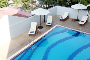 Una piscina al aire libre, tumbonas