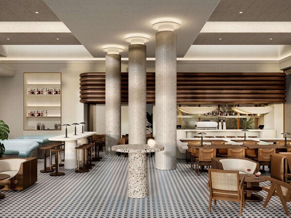 Un interior moderno con techos altos, grandes columnas, una mesa redonda central y una zona de bar.