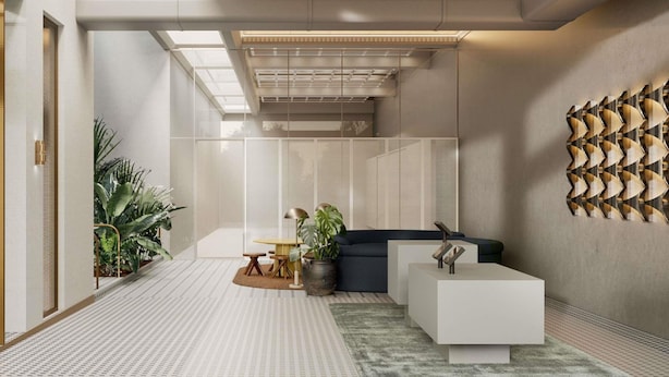 A modern interior with a glass partition, a sofa, a coffee table, and a patterned floor. - Novotel St Kilda (St Kilda)
