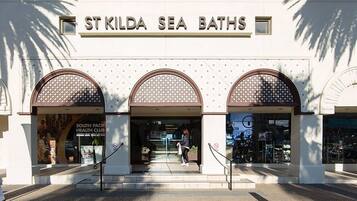 St Kilda Sea Baths features an arched entrance with a sign and patterned windows.