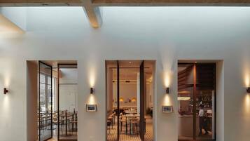 A modern interior with a reception area, dining space, and bar.