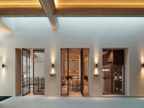 A modern interior with a reception area, dining space, and bar.