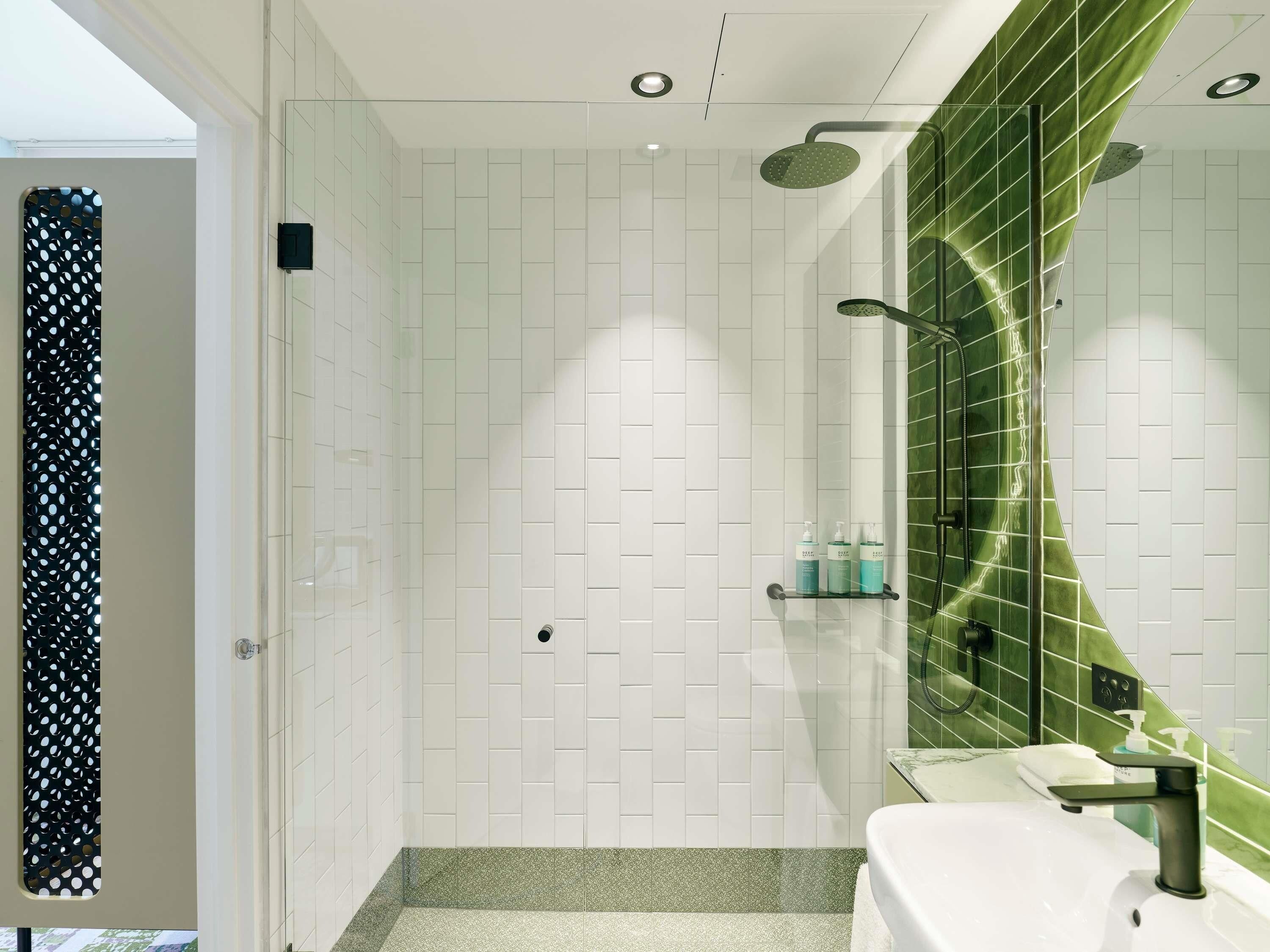 A modern bathroom with a shower, a sink, and a mirror.