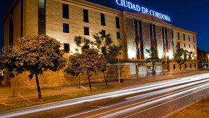 Un hotel con un cartel llamativo que dice "CIUDAD DE CORDOBA" de noche.