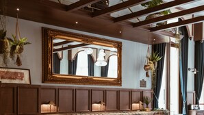 Ein Restaurant mit einer langen Theke, Sitzecken und roten Stühlen.
