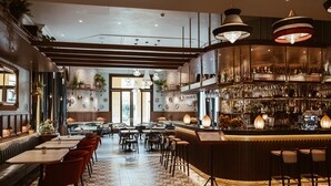 Ein Restaurant mit Barbereich, Sitzecken und einem gemusterten Boden.