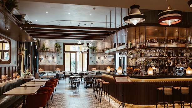 Ein Restaurant mit Barbereich, Sitzecken und einem gemusterten Boden.