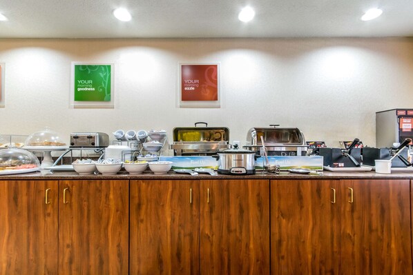 Un buffet proposant différents stands de nourriture, notamment un stand de plats chauds et un saladier.