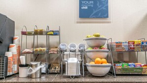 A breakfast bar with various food items and utensils.