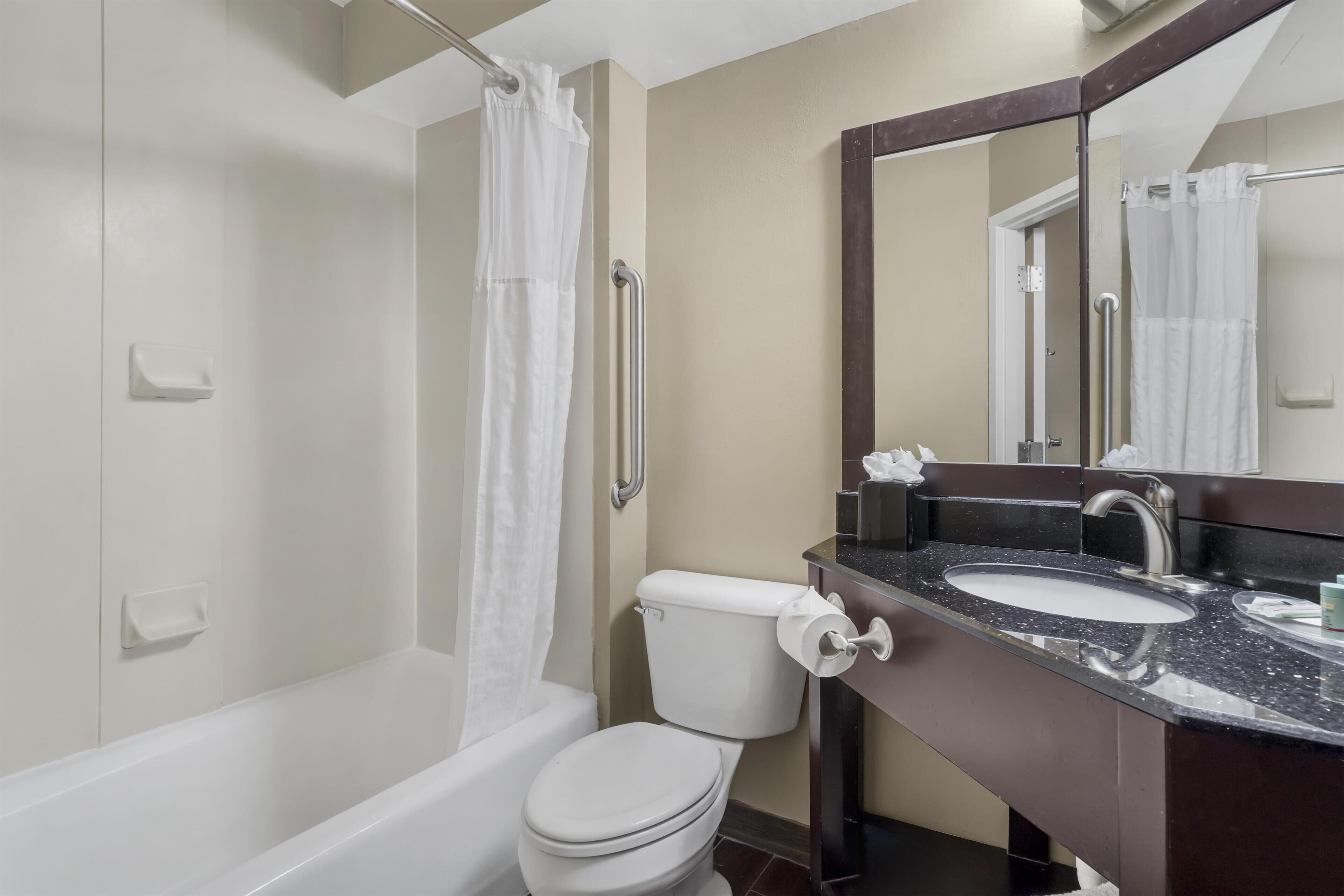 Un baño con bañera, inodoro y lavamanos.