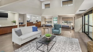 A spacious living area with a sofa, coffee table, and a view of the kitchen and dining area.