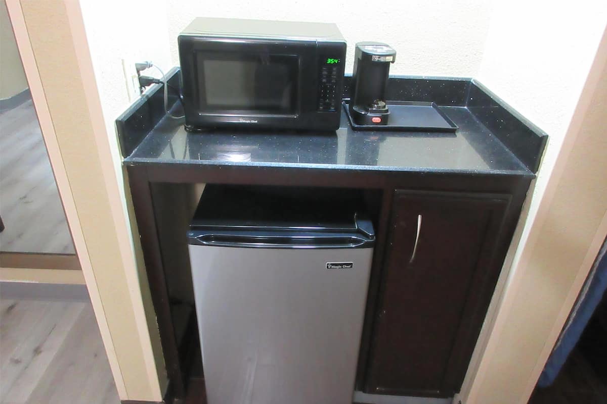 Escritorio, cortinas opacas, tabla de planchar con plancha