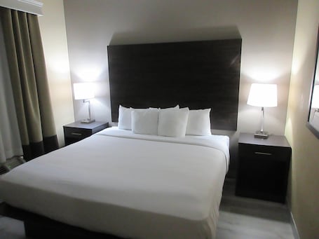 Escritorio, cortinas blackout y tabla de planchar con plancha