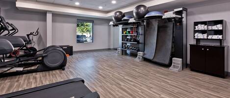 A gym with treadmills, exercise balls, and weight machines.