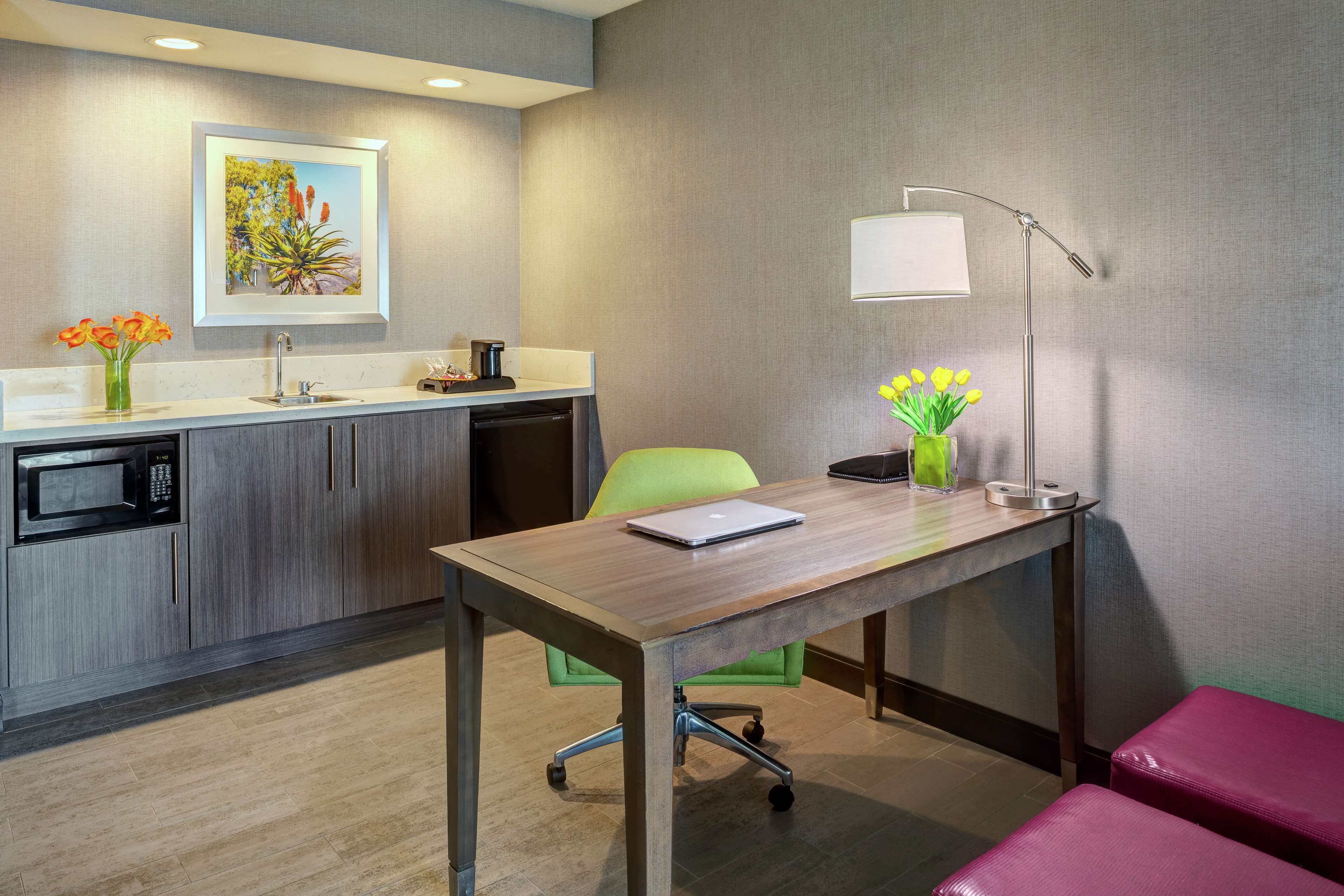 A modern kitchen with a microwave, sink, and a dining area with a table and chairs.