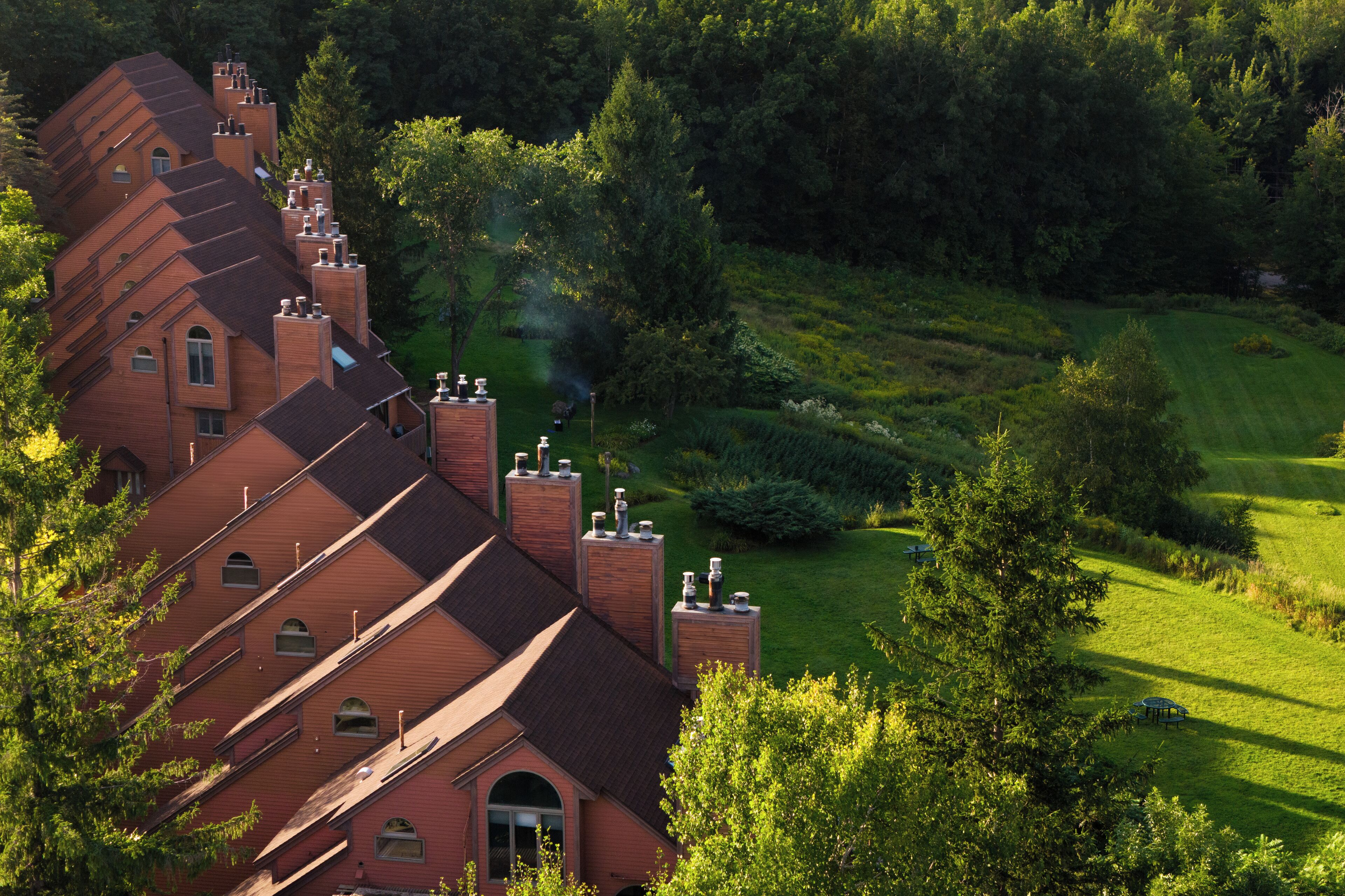Un grand immeuble à étages, doté d’une architecture originale, entouré d’une végétation luxuriante et d’une pelouse bien entretenue.
