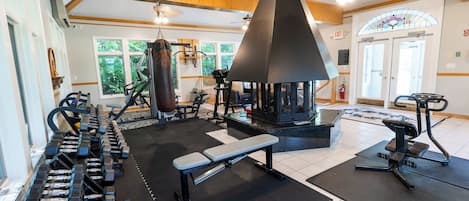 A gym with various exercise equipment, including dumbbells, a bench, and a punching bag.