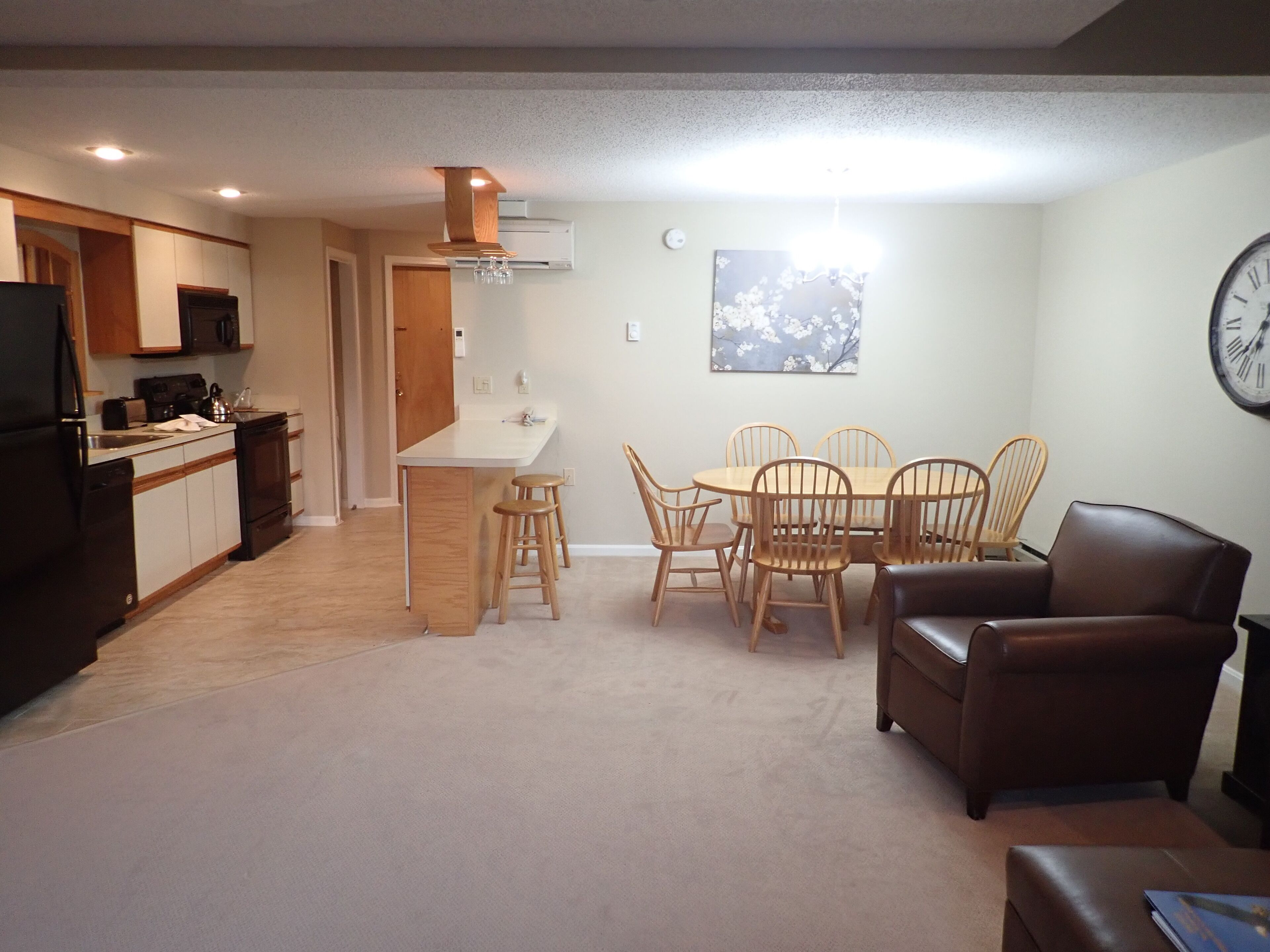 Een compacte woonruimte met kitchenette, eethoek en zithoek.