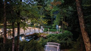 A serene garden with a wooden bridge, a pond, and a fire pit area. - Nordic Village Resort (Jackson)