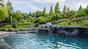 A natural pool with clear water, surrounded by rocks and greenery. - Nordic Village Resort (Jackson)