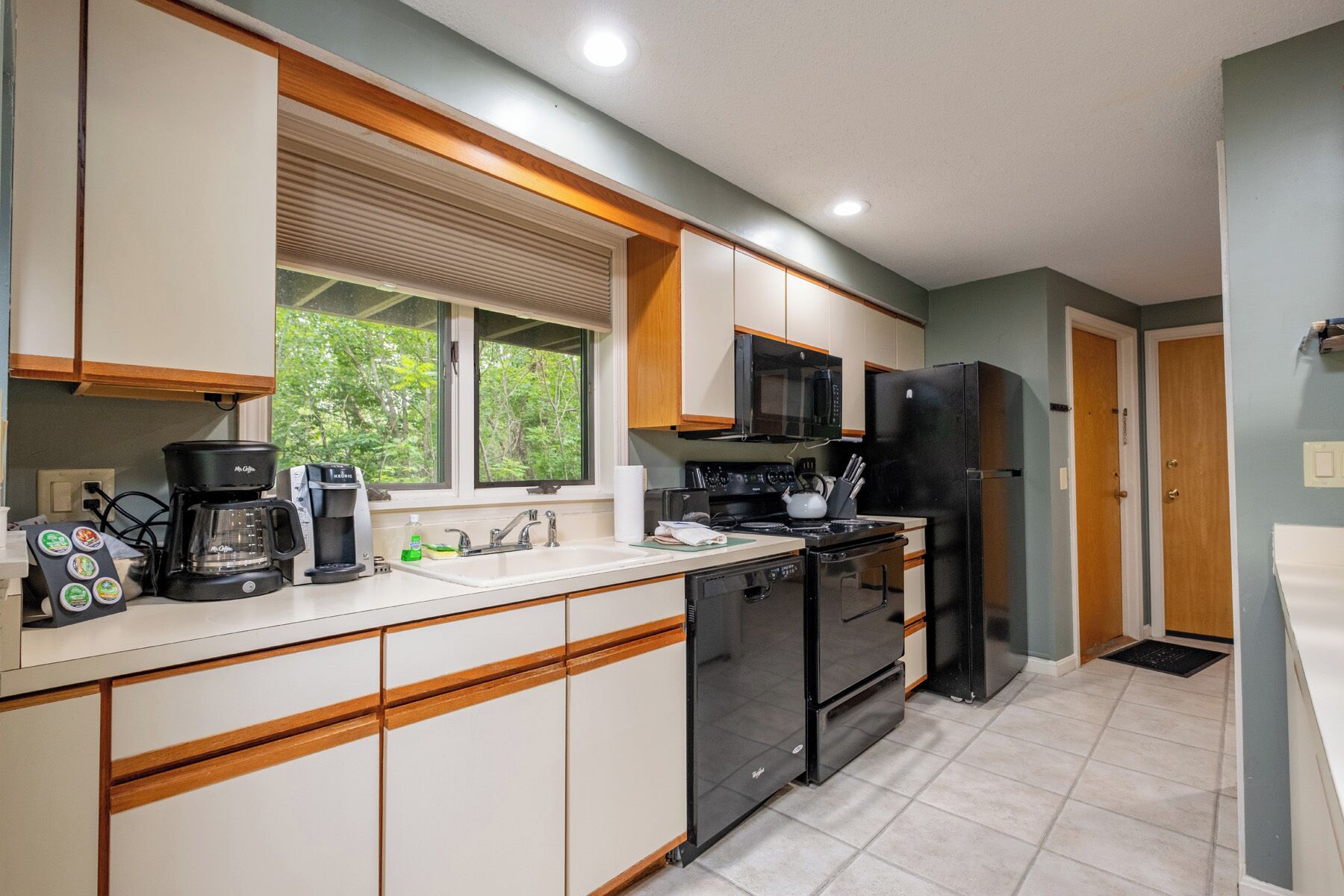 A modern kitchen with a coffee maker, microwave, stove, and refrigerator.