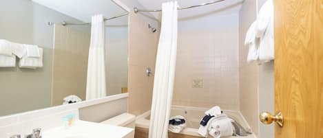 A bathroom with a bathtub, toilet, and sink.