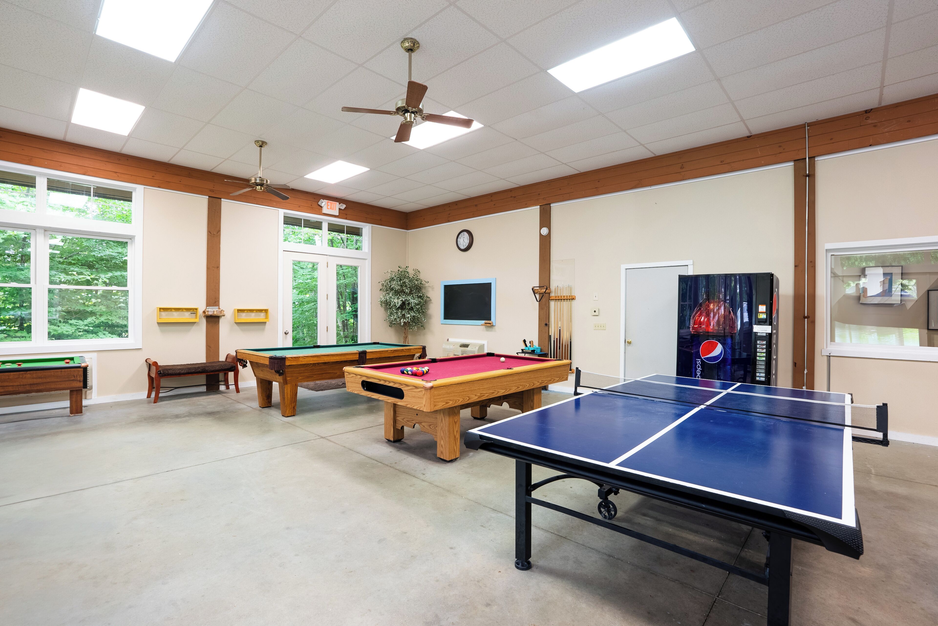 Une salle de loisirs équipée d’une table de billard, d’une table de ping-pong et d’une table de jeu de fléchettes.