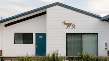 Un bâtiment blanc avec une porte bleue et le numéro 6104.