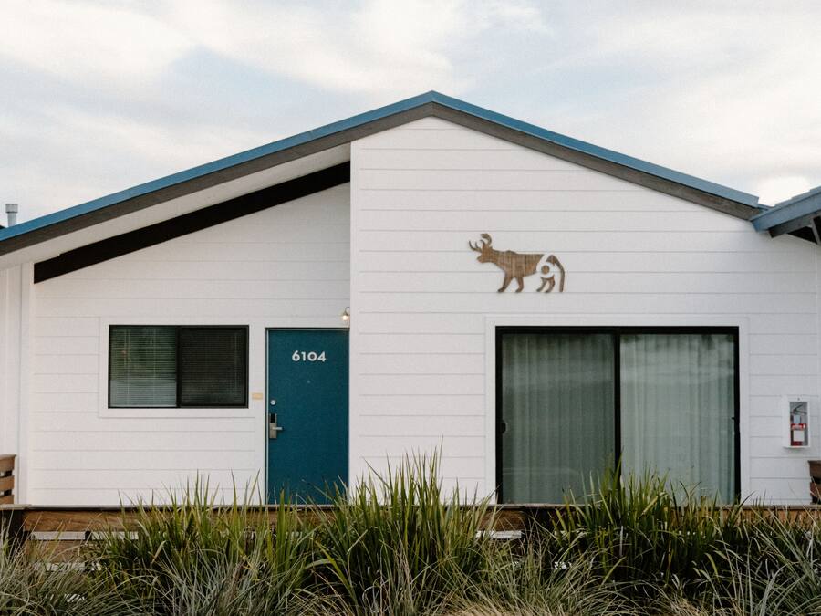 Un bâtiment blanc avec une porte bleue et le numéro 6104.