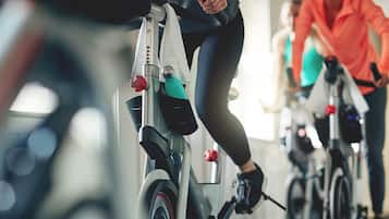 En person cykler på en stillastående motionscykel i et fitnesscenter.
