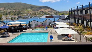 A pool area with a view of a mountain and a town in the background.