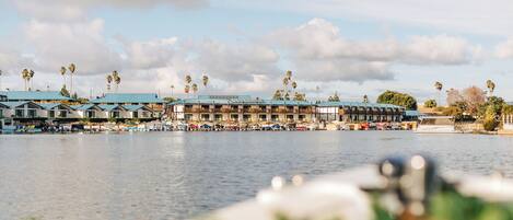A waterfront hotel with multiple buildings, a marina, and palm trees.